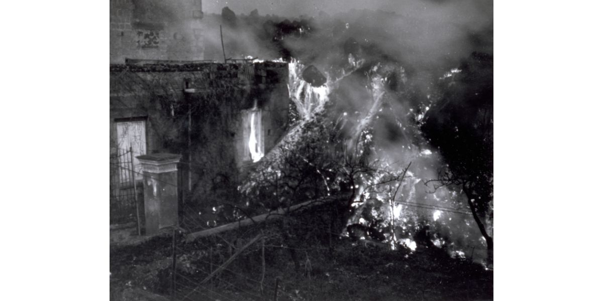 Unidentified author, Incandescent lava flow from Mount Vesuvius invests a building near Naples, March 1944, gelatin silver print on paper, 10.5 x13 cm, Alinari Archives-album collection, Florence