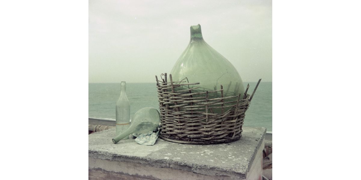 Vincenzo Balocchi, Damigiana e bottiglie di vetro, Cecina, aprile 1961, pellicola in acetato di cellulosa alla gelatina sali d’argento a colori, 6 x 6 cm, Archivi Alinari-archivio Balocchi, Firenze