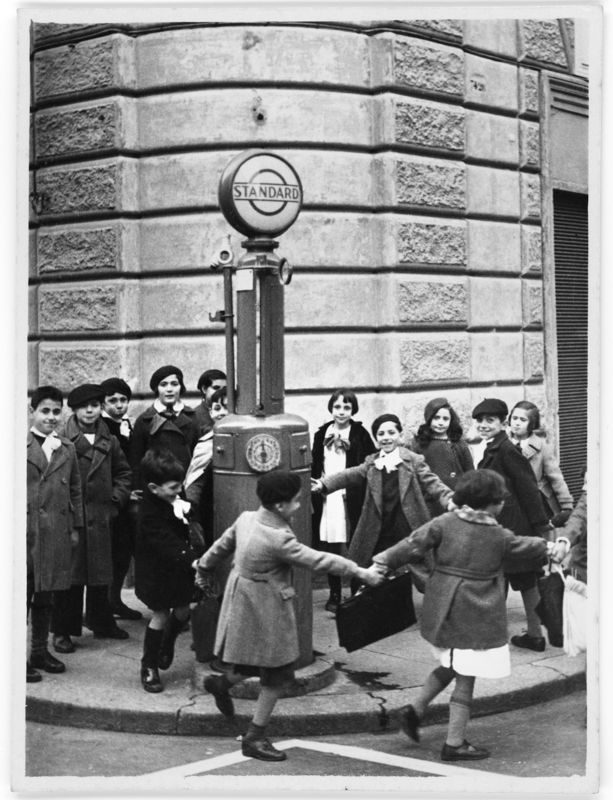 Luigi Leoni, Scolari in girotondo intorno a un distributore di benzina, Roma, 1935, stampa alla gelatina ai sali d’argento, Archivio Luigi Leoni / Archivi Alinari