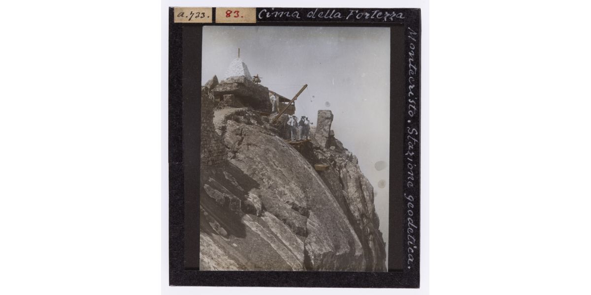 Giorgio Roster, “Cima della fortezza Montecristo. Stazione geodetica.”, 1890-1910 ca., diapositiva su lastra di vetro colorata a mano, 9 x 8 cm, Archivi Alinari-archivio Roster, Firenze