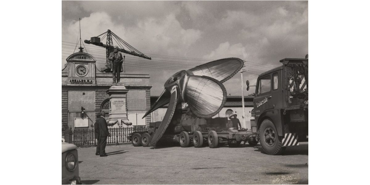 Foto Betti (Giuseppe Borra), Elica sul rimorchio di un camion davanti ai cantieri Luigi Orlando dell'Ansaldo a Livorno, 1950-1960 ca., stampa alla gelatina ai sali d’argento, 18 x 23,5 cm, Archivi Alinari-archivio Betti Borra, Firenze