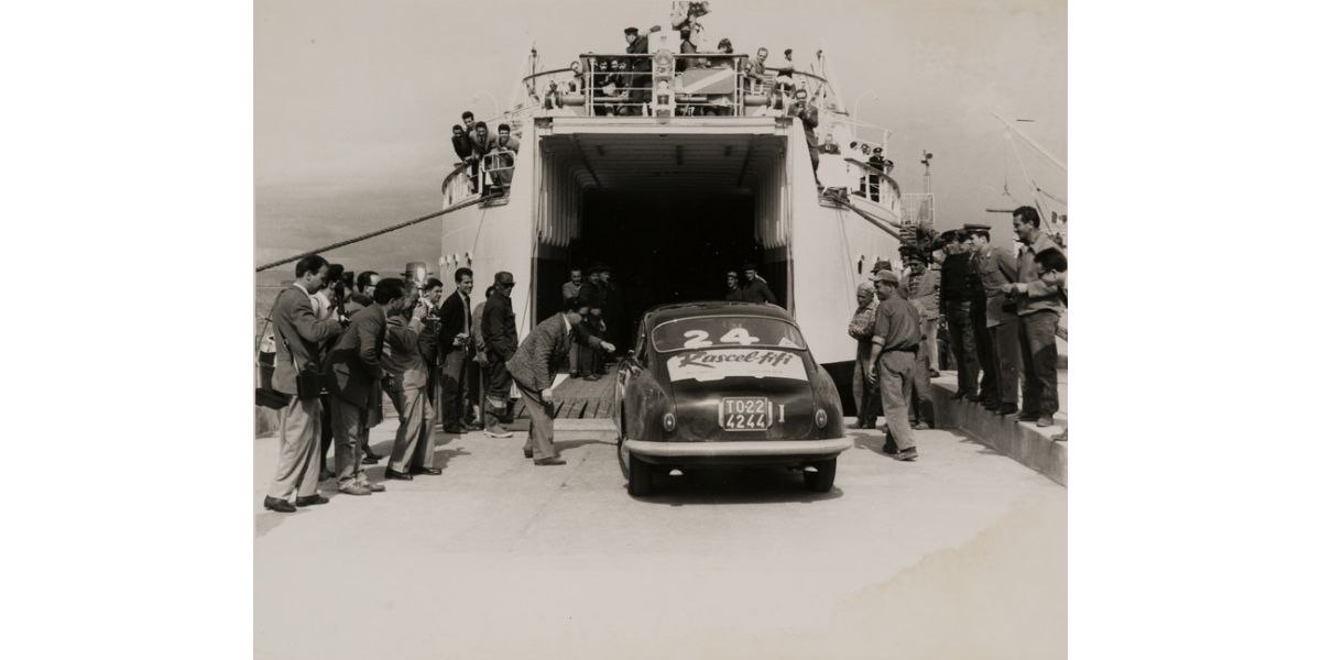 Foto Betti (Giuseppe Borra attr.), Automobile da corsa sale su un traghetto, Livorno, post 1957, stampa alla gelatina ai sali d’argento, 21 x 25,5 cm, Archivi Alinari-archivio Betti Borra, Firenze