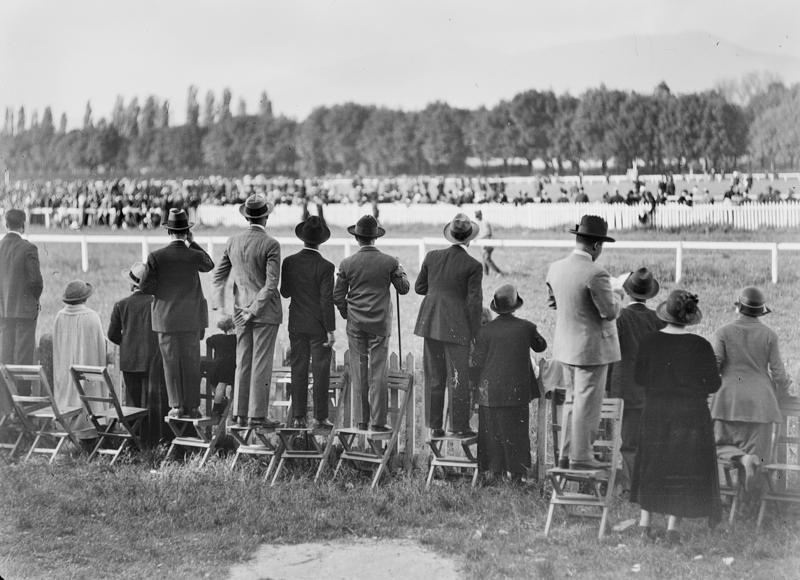 Fotografia in bianco e nero che ritrae uomini in piedi sulle sedie all'ippodromo delle Cascine